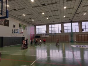 Trening koszykówki na wózkach, jedna osoba wrzuciła piłkę do kosza