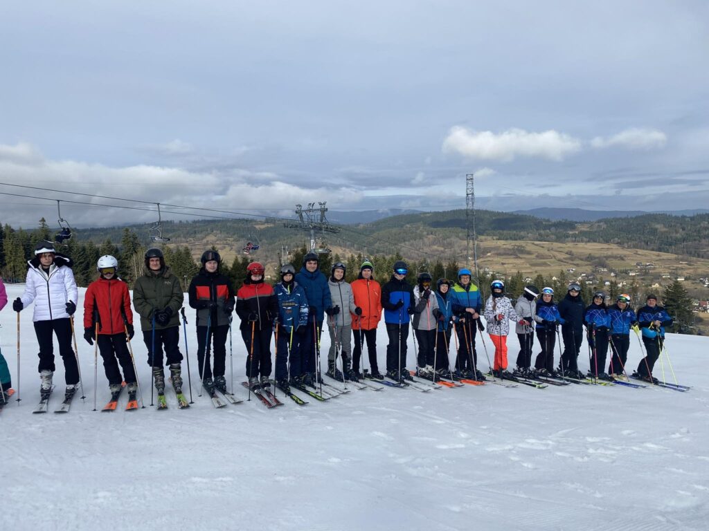 Grupa narciarzy stoi na stoku narciarskim